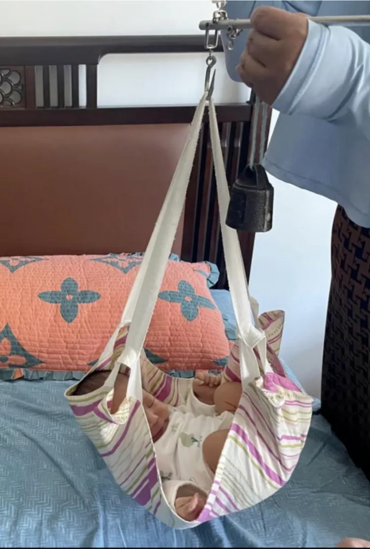 中國多地仍用古法以桿秤為嬰兒量體重。翻攝微博/桿秤量體重