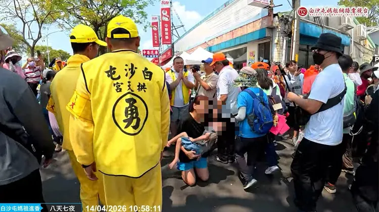 婦人抱著重病兒子，白沙屯媽鑾轎特別停留5分鐘之久。取自白沙屯媽祖網路電視台