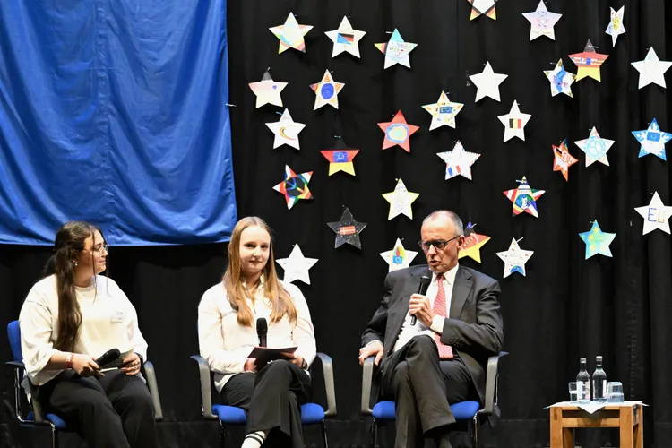 德國總理梅爾茨（右）與德國學子座談。美聯社