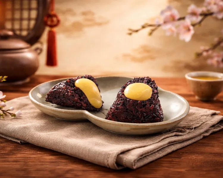 「紫米奶黃流沙粽」讓甜點控魂牽夢縈，金黃熔岩內餡與微甜紫米完美重現粵式經典流沙神韻，每顆188元。台北遠東香格里拉提供