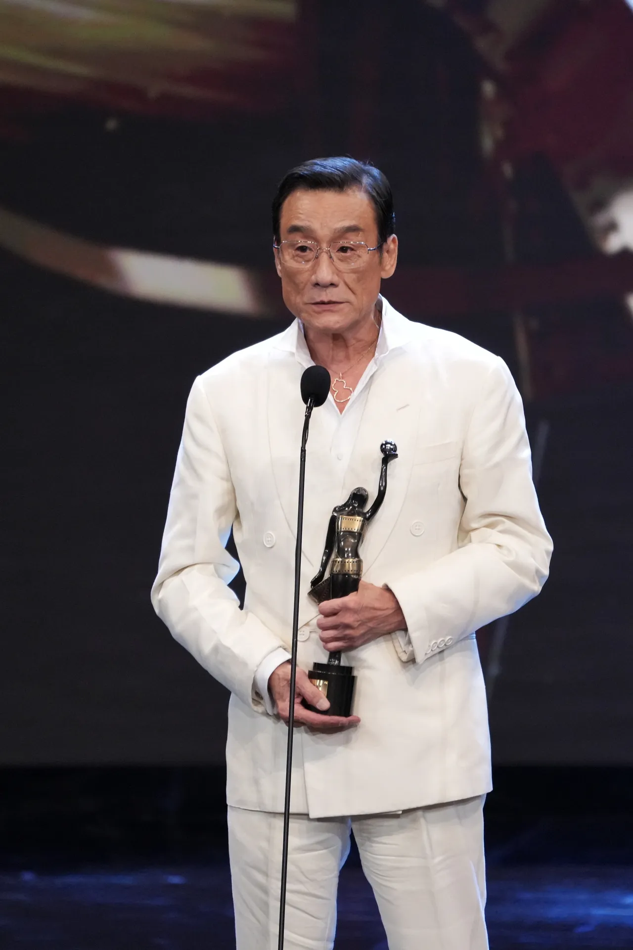 梁家輝以白色西裝搭配Qeelin Wulu Grande 18K白金鑲鑽項鍊。品牌提供