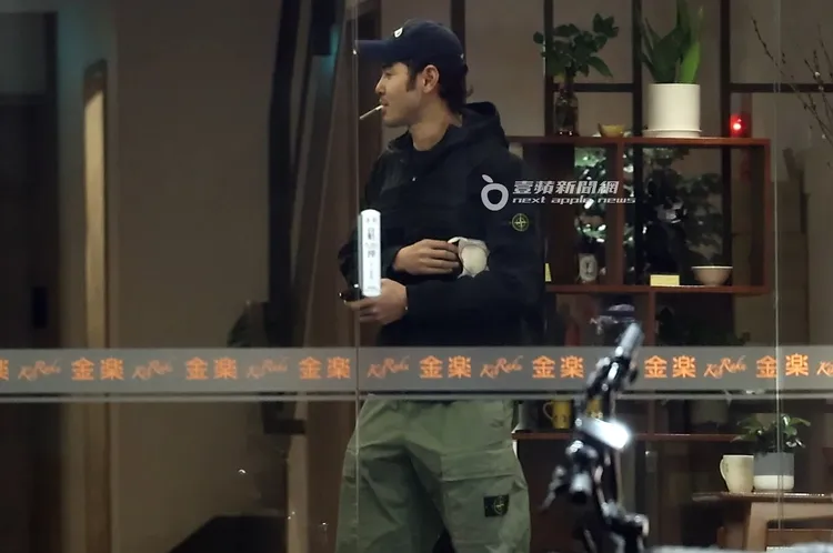 小天嘴叼著捲菸，一邊道別邊走出按摩會館。特勤中心攝。《壹蘋》提醒您，吸菸有害健康