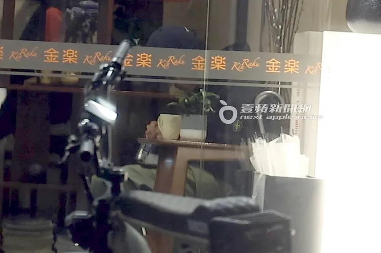 小天坐在休息區，從收納袋拿出菸草準備捲菸。特勤中心攝