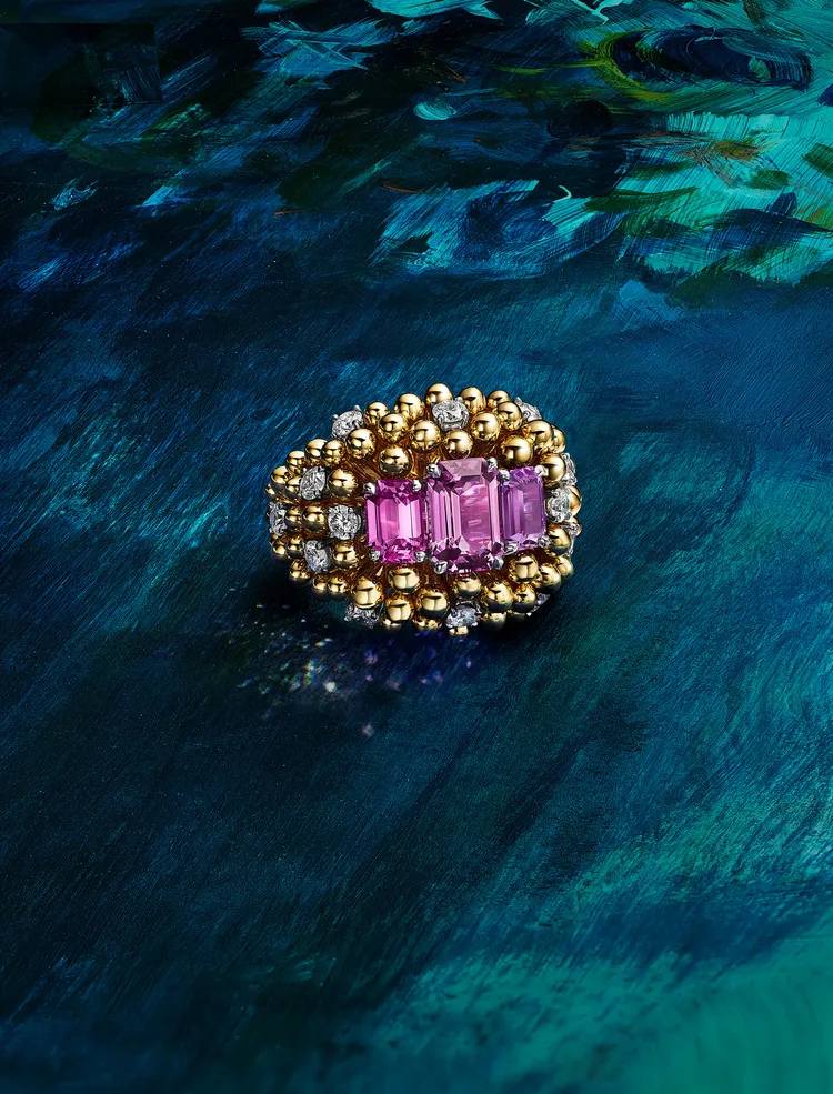金蕊綻芳篇章鉑金和黃K金戒指，鑲嵌兩顆總重4.47克拉的未經處理的祖母綠切割粉紅色藍寶石、一顆1.55克拉的未經處理的祖母綠切割紫色藍寶石和鑽石。品牌提供