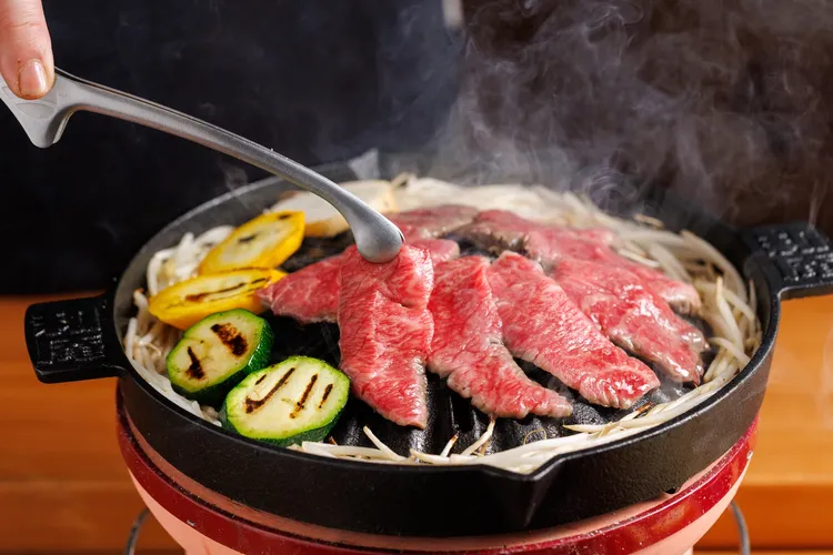 當季時蔬與A5和牛在炭火上炙烤，香氣蒸騰。豊漁餐飲集團提供