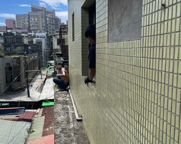 移工在外牆與警消對峙中。桃園市消防局提供