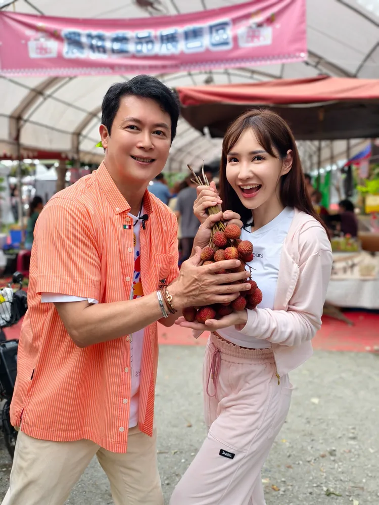 王燦（左）和徐千金對荔枝愛不釋手。民視提供