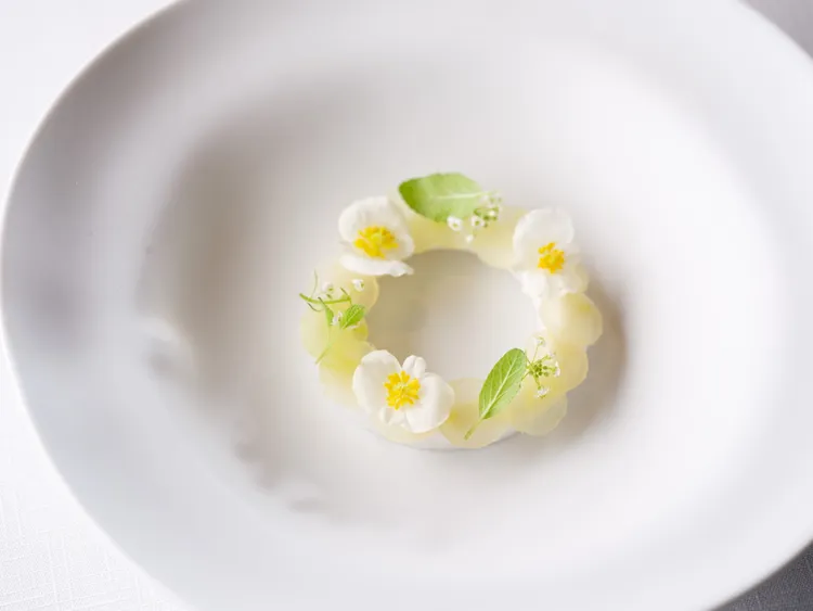 經典料理「花舞」，以極致精準的法式美學將時令花卉、嫩葉與透亮薄片和諧排列成和諧的花環，展現萬物隨季節循環的平衡之美，彷彿一場優雅的盛夏感官交響詩。。業者提供