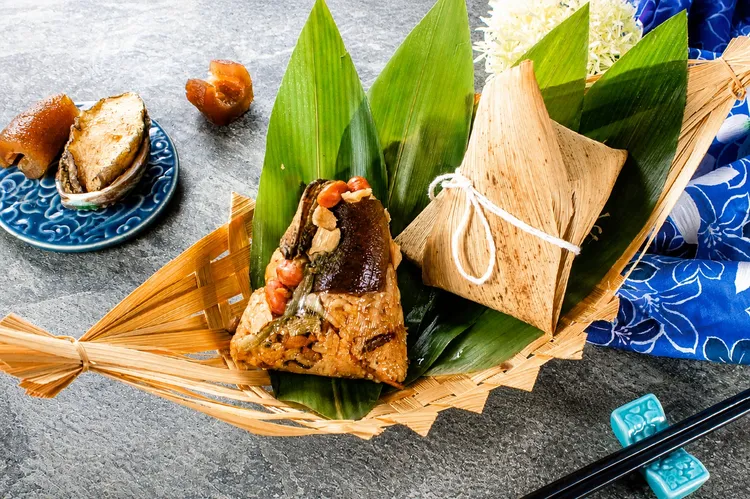 「客家鮑魚海鮮粽」選用鮑魚、烏參、干貝與魷魚等海味精華，搭配豬肉、香菇、蝦米與花生，透過客家料理手法調和鹹香比例，讓山珍與海味在口中交織出濃郁層次。每一口都能感受到食材本身的鮮甜與厚實，呈現出高端海味體驗。桃禧飯店集團提供