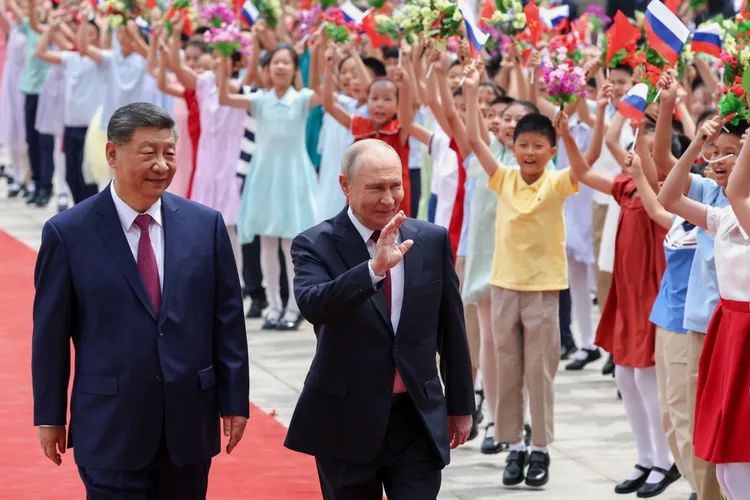 習近平在人民大會堂外安排兒童歡呼跳躍歡迎普丁，上周川普來時也上演過同樣情景。美聯社