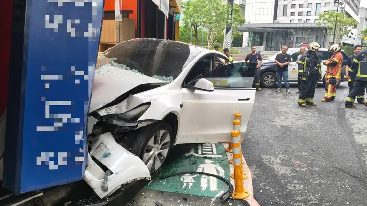 特斯拉車頭撞上家具行外牆梁柱後停下，車頭全毀。翻攝畫面