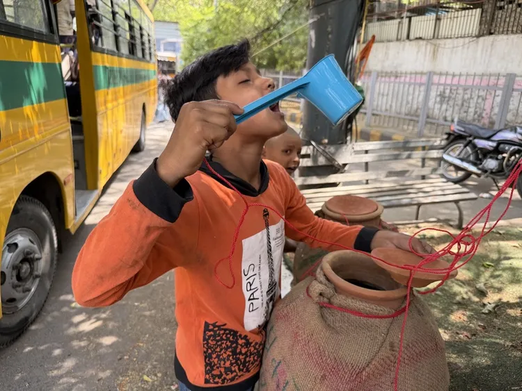 印度氣溫連續多日飆高溫，最高測得47.6度，政府敦促民眾盡量待在室內、多補充水分。圖為新德里街頭，取水飲用的民眾。中央社