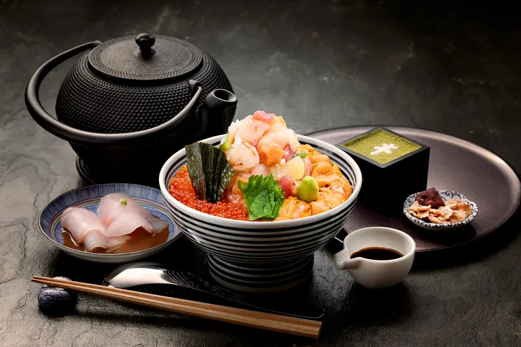 日本橋海鮮丼辻半推出單筆消費滿1200元，即可獲得「第二份主餐五折券」優惠，經典海鮮丼推薦特上珠寶盒1499元。業者提供