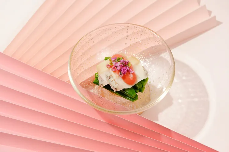 前菜「鮑 甜豆 醋味噌」盛於透明器皿中，粉、綠、紫色澤交映，清雅如春。日勝生加賀屋提供