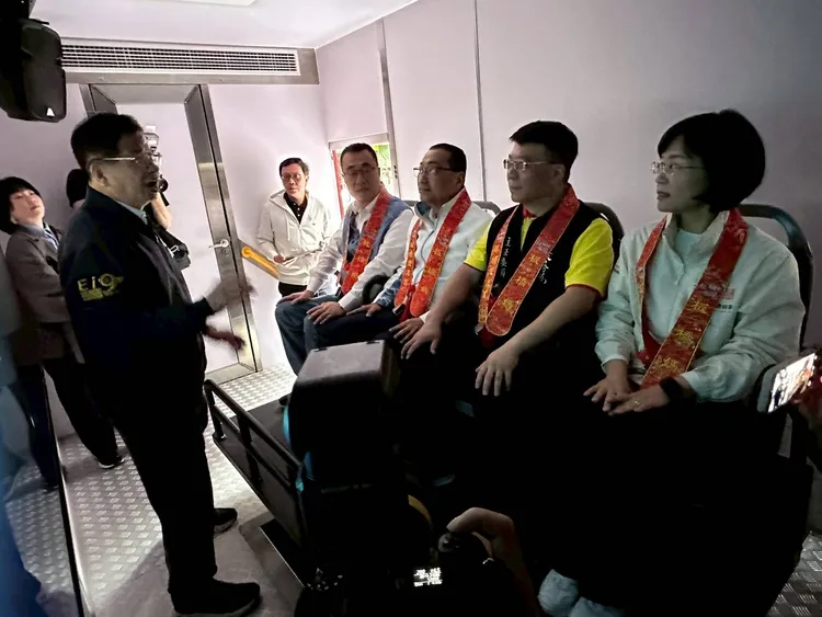新北市消防局局長陳崇岳向慈惠宮主委賴春穆、市長侯友宜以及兩名市長候選人李四川及蘇巧慧說明最新型地震體驗車功能。消防局提供