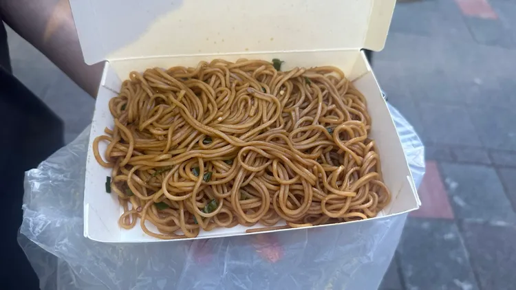 黃仁勳特地帶著滿滿餐盒步出餐廳，第一次發放飲料與炒麵。呂承哲攝