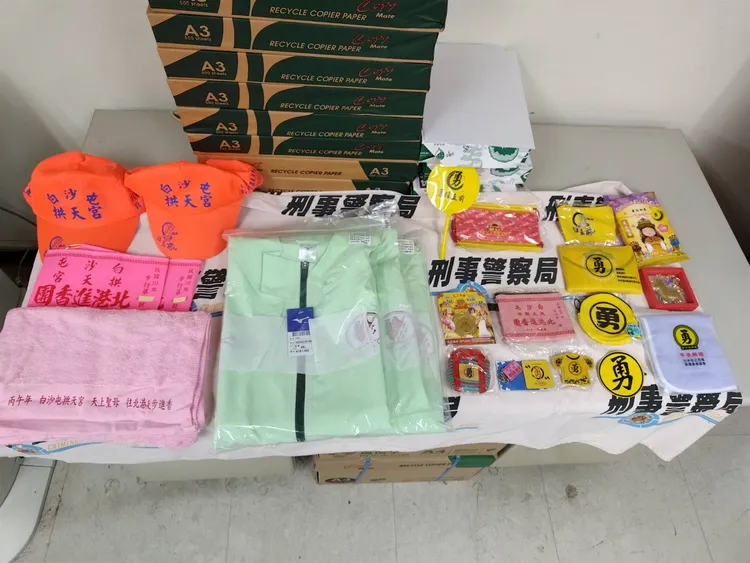 警方屋內查扣手機、白沙屯媽祖進香外套、帽子、臂章、毛巾、報名表及相關結緣品等證物。翻攝畫面