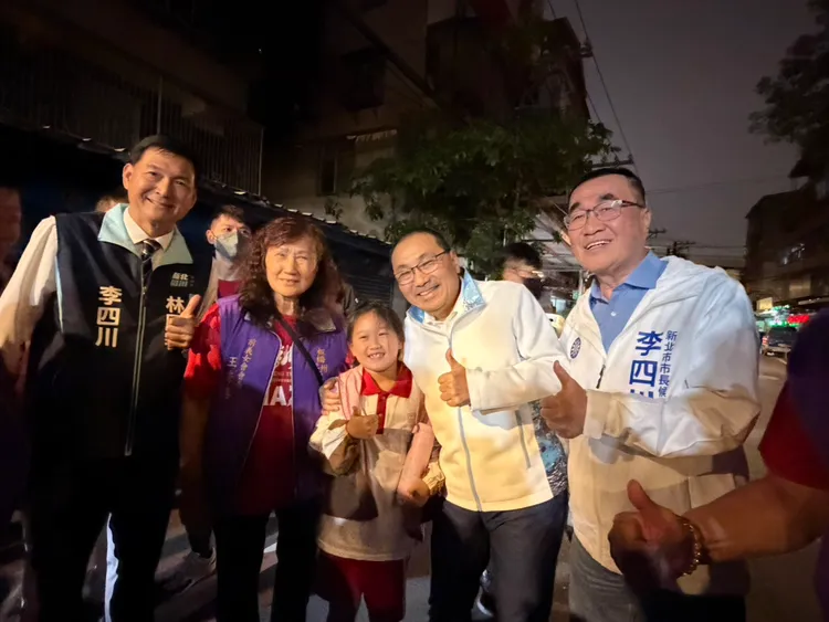李四川和新北市長侯友宜共同參加板橋浮洲天聖宮天上聖母聖誕平安宴，熱情和鄉親合影。競辦提供