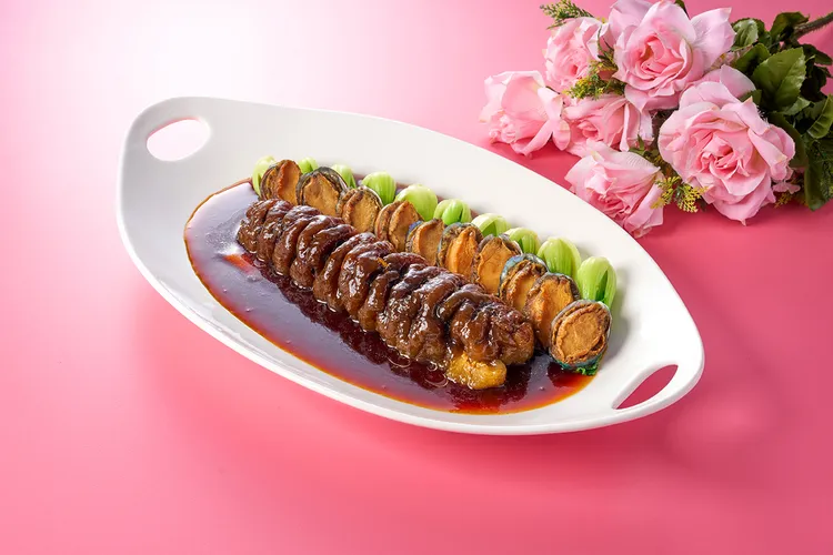 「干煎鮑魚黑玉參」嚴選整條頂級黑玉烏參入菜，搭配鮮嫩彈牙的鮑魚，以細火乾煎鎖住食材精華，口感滑順且富含膠質，交織出鮮醇濃潤的層次風味。瀚寓酒店提供