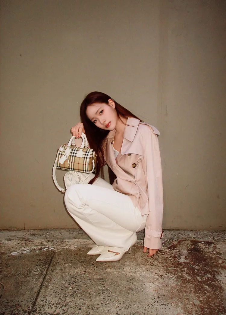 Lily以短版粉色風衣穿出甜美感，並腳踩尖頭高跟鞋為整體時髦度定調。品牌提供