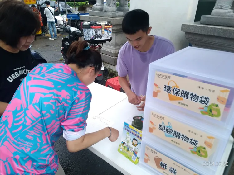 台灣公民參與協會理事長何宗勳建議可借鏡YouBike成功經驗，以「良幣驅逐劣幣」打造環保夜市。圖為新豐夜市轉型環保夜市，自購購物袋及環保杯享好康。新竹縣府提供