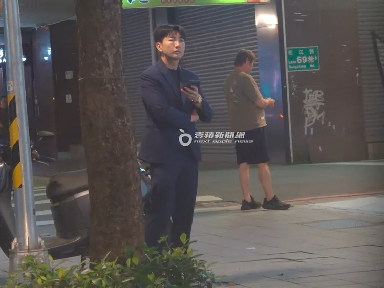 鉅星匯餐飲集團董事長吳政男的兒子吳亞璟，在自家高級鐵板燒餐廳外滑手機回訊息，迎接客人到來。特勤中心攝