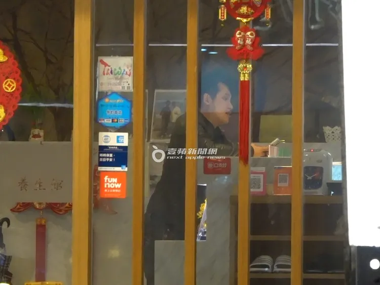 梁軒安在自家經營的「昇之道健康養生會館」櫃檯跟店員聊天。特勤中心攝