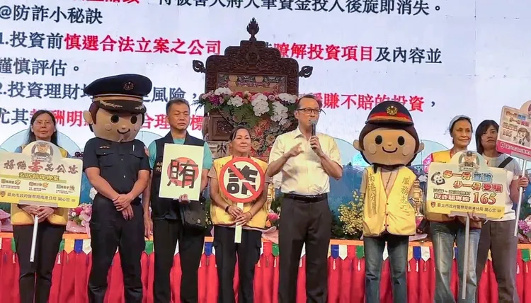 分局長洪漢周（右四）率南港打詐隊於佛誕浴佛祈福盛典現場剖析新型態詐騙手法。翻攝畫面