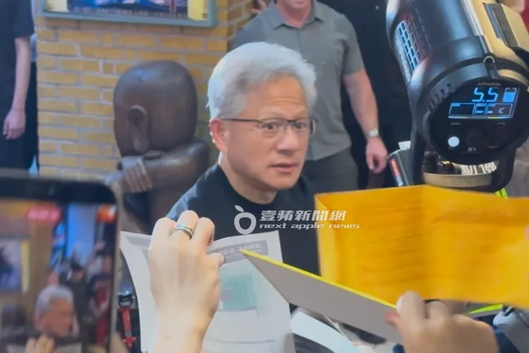 黃仁勳幫粉絲簽皮夾後抽了一張千元大鈔給現場的小粉絲。特勤中心攝