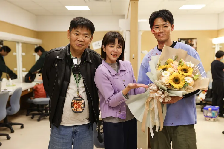 蘇晏霈（中）準備殺青花束送給羅子惟（右），左為導演馮凱。民視提供