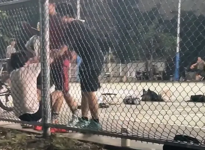 黑衣李男毆打坐在球場旁的葉姓少年，紅衣男上前勸止。翻攝Threads/yan____.0627