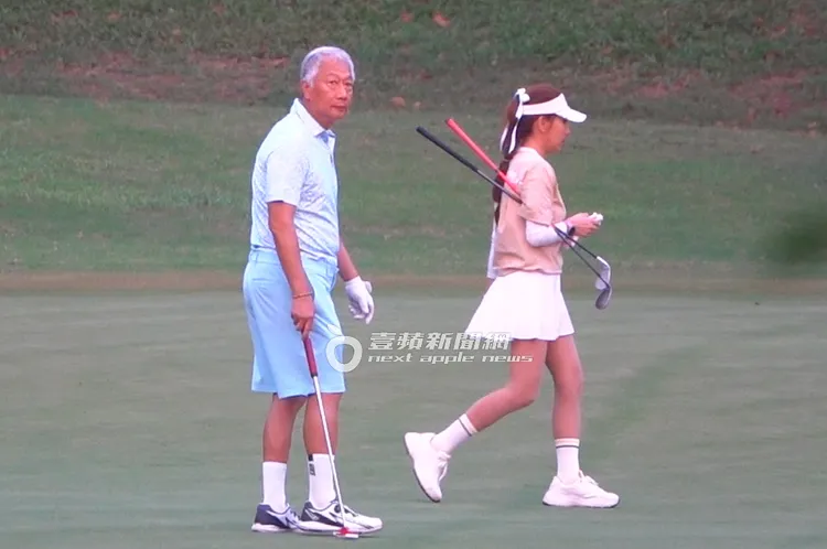 郭台銘（左）拿球桿漫步在草皮上，一路上都有謝女相伴。特勤中心攝
