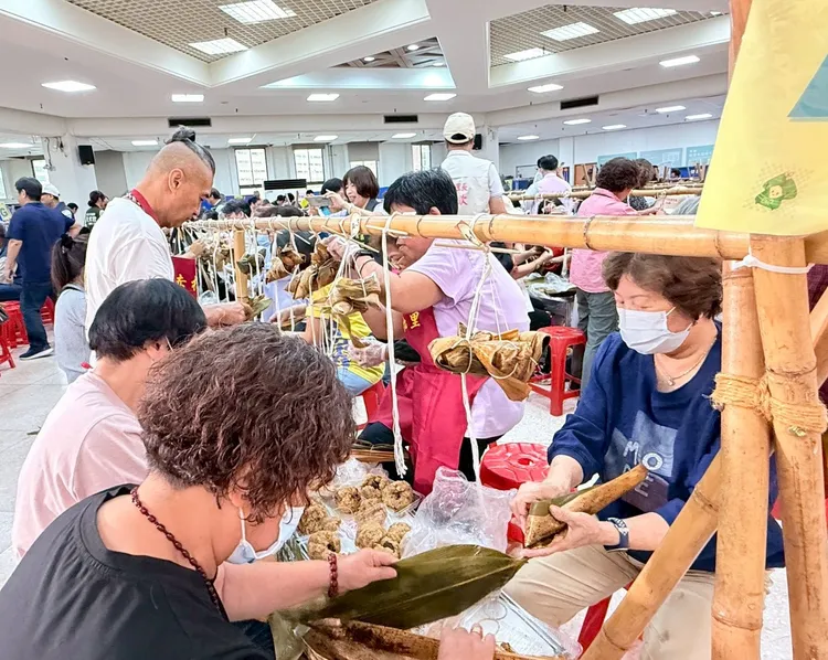 里長、志工認真包粽，齊心協力完成一串串充滿祝福的粽子。公所提供