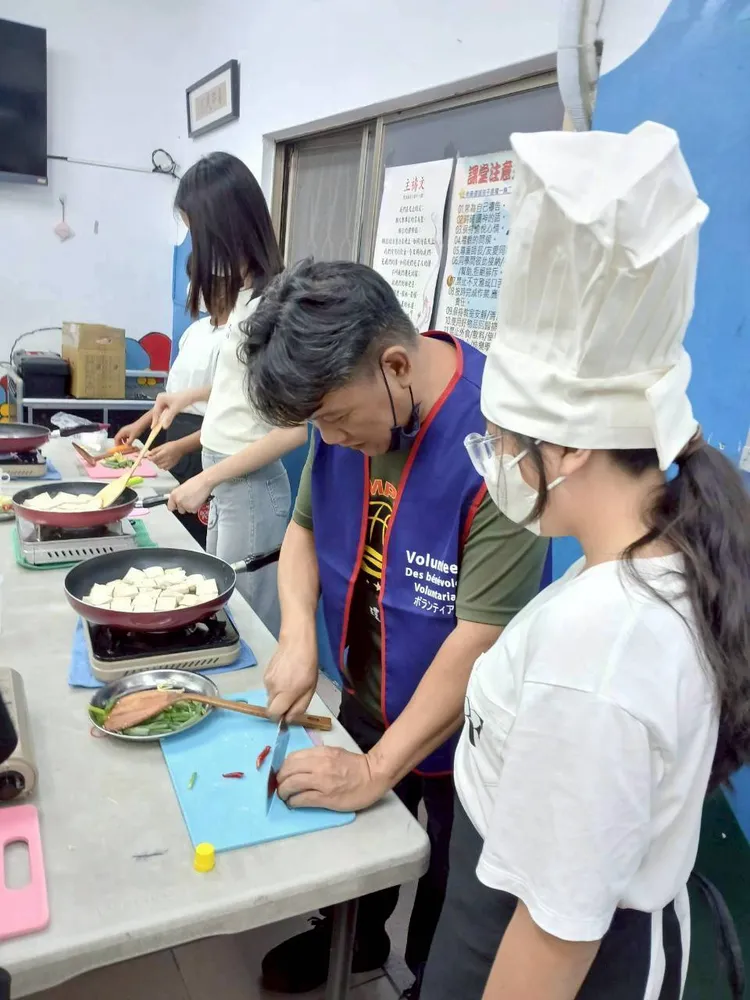 志工陪伴孩子學做料理，生活技能從廚房開始紮根。珍妮主任提供