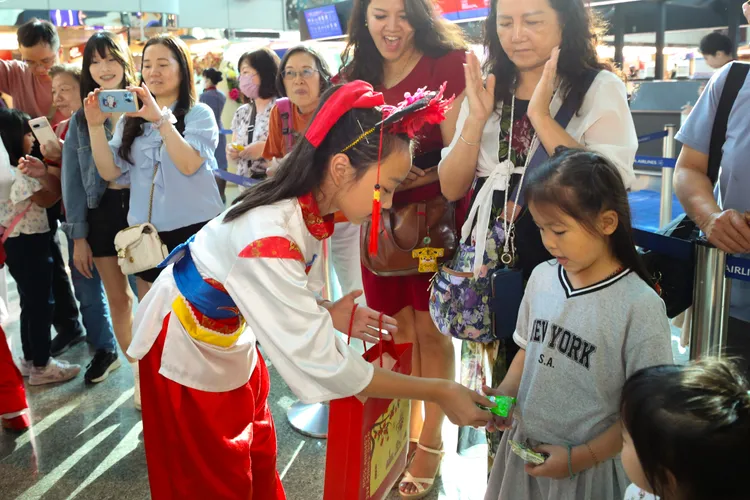 金門中正國小鼓吹隊員與旅客互動，分享來自金門的文化熱情。財團法人昇恒昌基金會提供