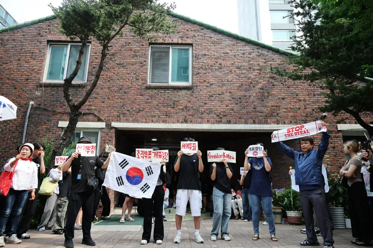 民眾包圍投票所不讓投票箱運出。路透