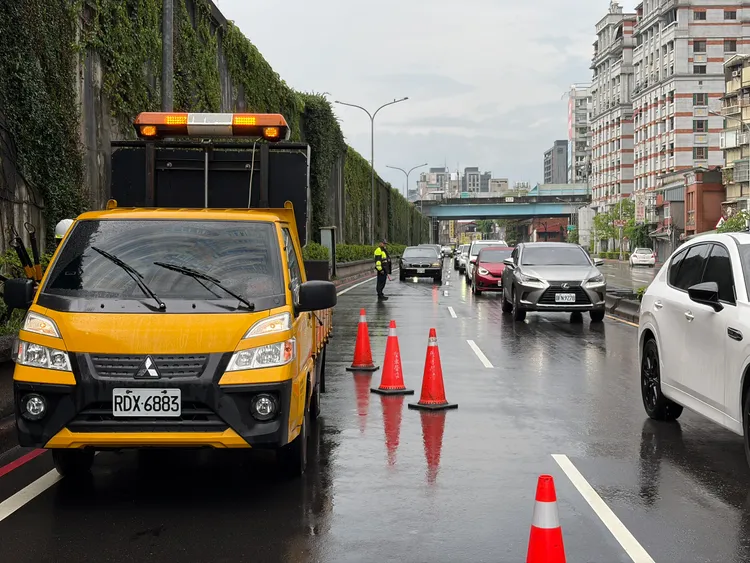 環河北路一段車道的人孔蓋因水壓噴飛，相關單位到場維修。北市府提供