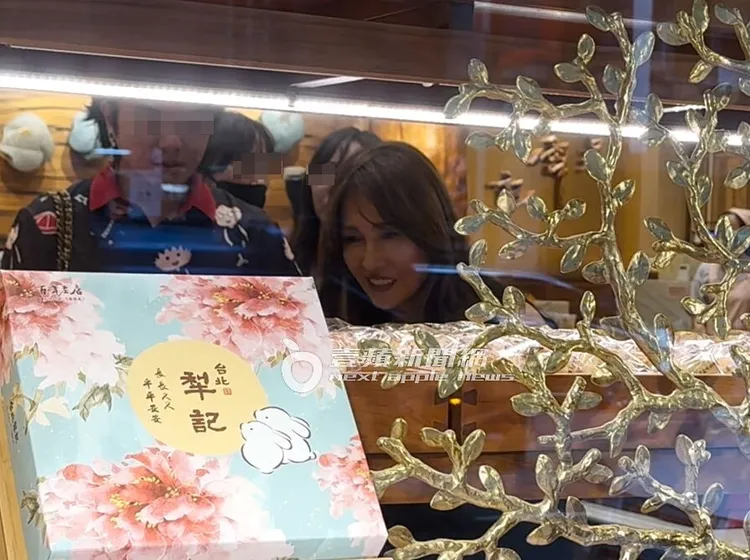 工藤靜香彎腰好奇看著展示櫃前的糕餅。特勤中心攝