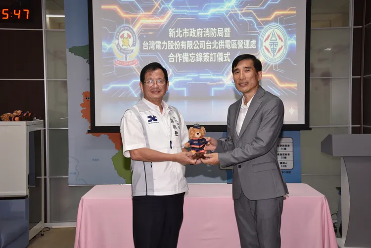 新北市消防局長陳崇岳致贈台電台北供電區營運處長馬偉富「熊平安」吉祥物。消防局提供