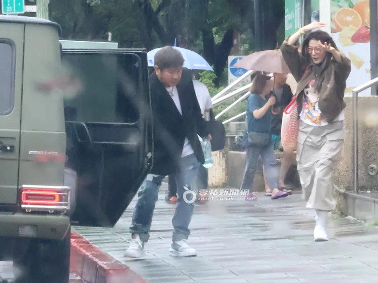 當天下起午後雷陣雨，胡瓜（左）先幫丁柔安開車門。特勤中心攝