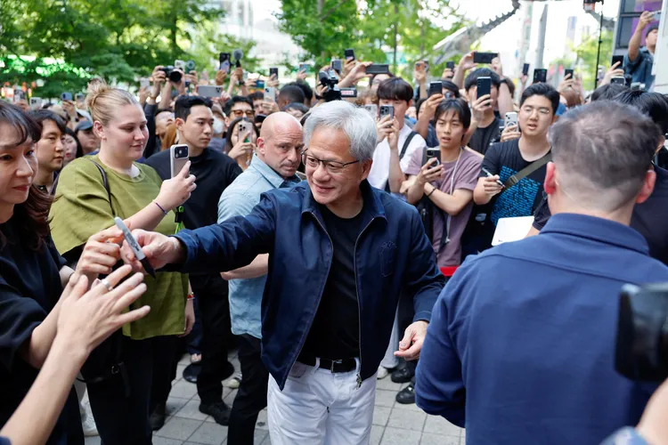 黃仁勳替民眾簽名。路透