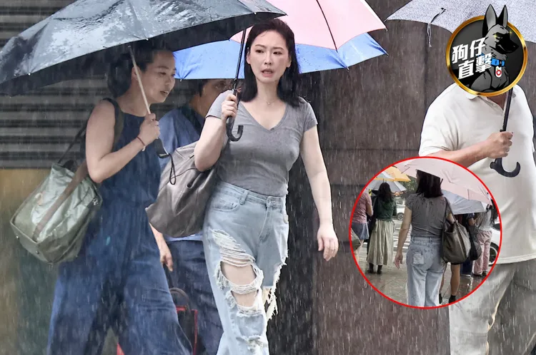 王俐人撐傘，和經紀人邊走邊聊。特勤中心攝