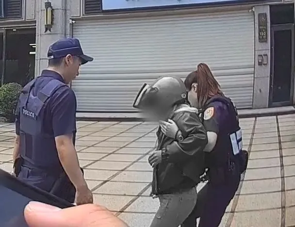 女警攙扶至路旁安全處所休息。中壢警分局提供