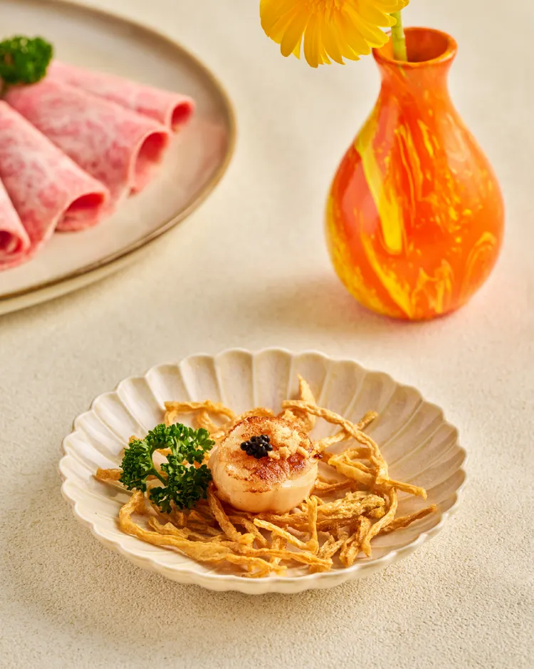 「好事發生・壽喜燒限定套餐」中亦包涵創意海味「蒜香干貝煎」，以魚子醬作點綴，品嚐得到干貝的甜、魚子醬的鮮，更加入炸鱈魚絲以及可樂果，增加獨特風味與口感層次。業者提供