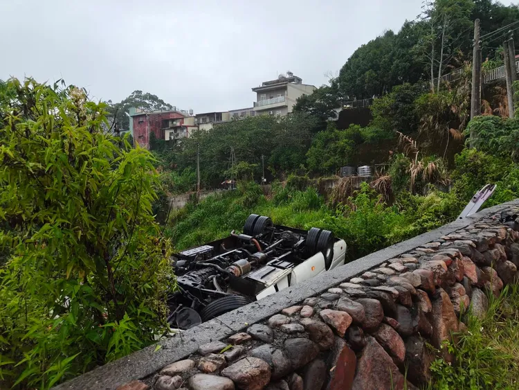 中型巴士衝進邊坡翻覆。民眾提供