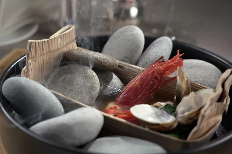 礁溪了了的晚餐可品味慢食三星融合原民美學的Tasting Menu，圖為月桃葉鹽封下的鮮甜海魚、熱石與檳榔葉鞘激盪出的鮮美魚湯。雲品國際提供
