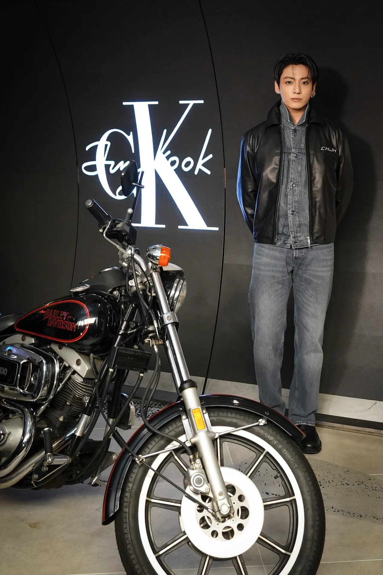 田柾國以訂製版皮革賽車夾克搭配丹寧外套亮相。品牌提供