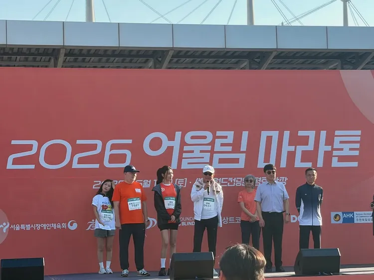 秀英（左三起）與擔任失明防治運動總部會長的父親崔貞楠一起上台，為參賽者們打氣。翻攝失明防治運動總部IG