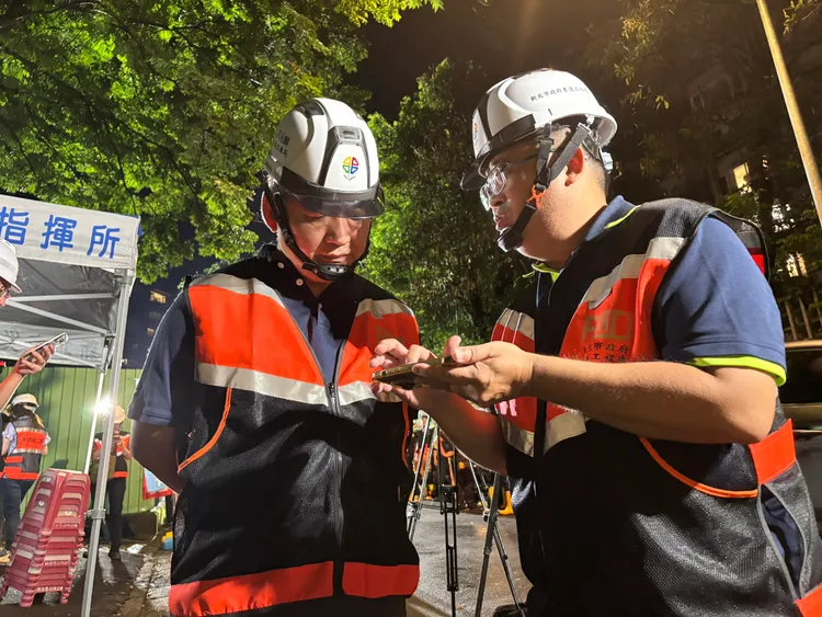 工務局長馮兆麟（左）到現場勘查，將連夜加裝建築物監測儀器掌握安全狀況，並打設鋼軌支撐及帆布覆蓋。工務局提供