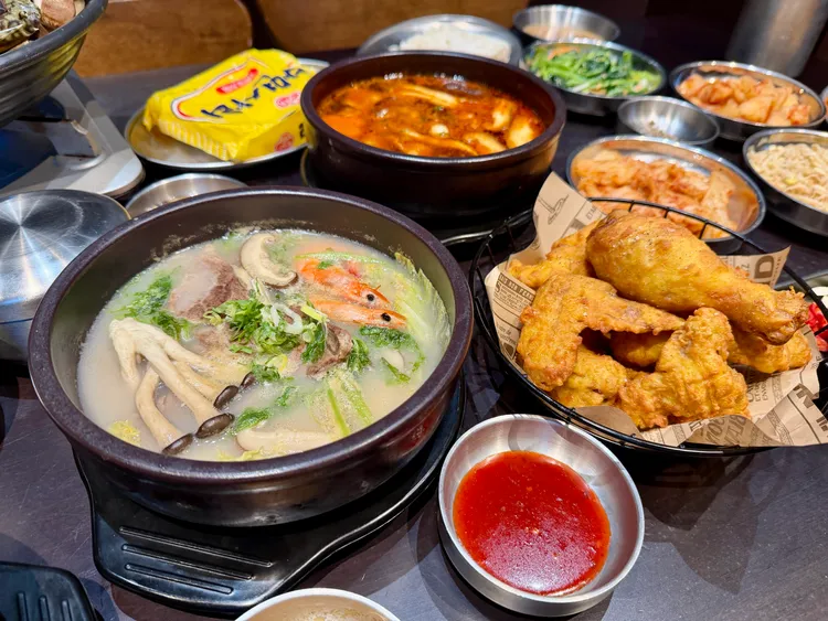 新上市的「韭菜豬肉海鮮湯飯」（左前）與韓式炸雞等餐點。莊偉祺攝